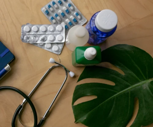 Un stétoscope, des médicaments et une feuille verte