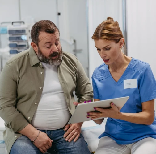 Un homme en surpoids parlant à une infirmière