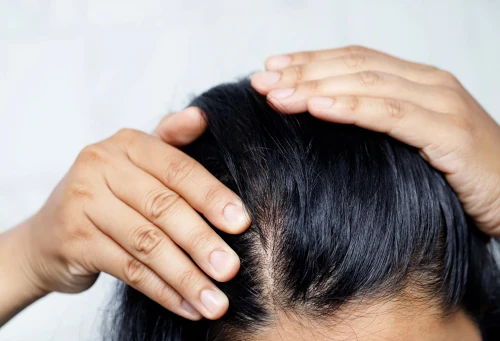 Une photo d'une femme se touchant les cheveux